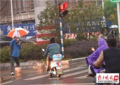 <b>退休老人雨中撑伞劝行人不要闯红灯(组图)</b>