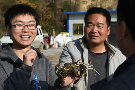 11月1日，黄龙县大闸蟹养殖专职技术员冯万能（左一）、石堡镇养殖技术员彭建民（左二）在向饲养户了解情况。