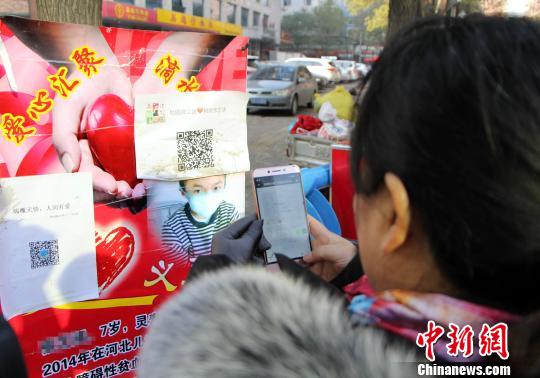图为爱心人士扫微信二维码进群。 韩冰 摄