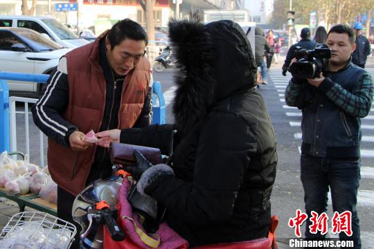 图为爱心人士购买张建永的产品。 韩冰 摄