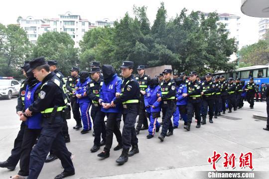 图为民警押解嫌疑人。警方供图