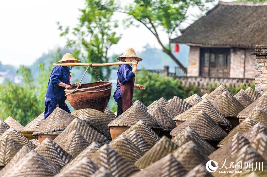 工人在酱油天然晒露发酵场里劳作。李贵平摄