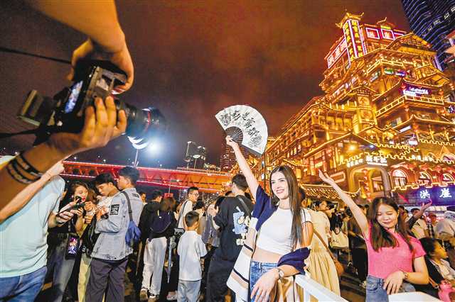 中秋国庆假期，渝中区洪崖洞景区，外国游客前来拍照打卡。首席记者 龙帆 见习记者 李雨恒 摄/视觉重庆